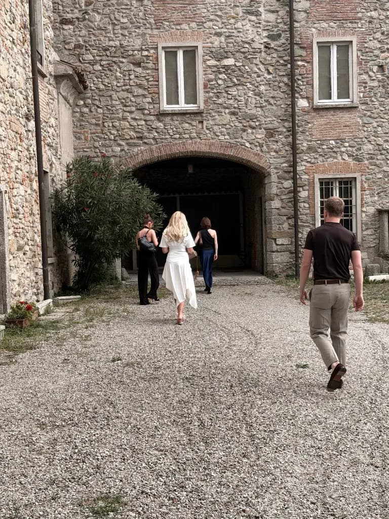 Group walking toward a stone archway in Milan
