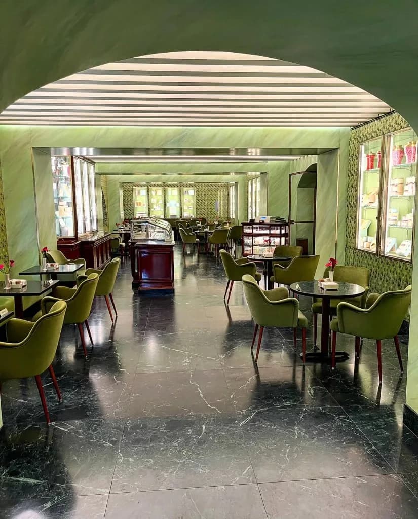 Café-Interieur in Salbeigrün mit dunklem Marmorboden