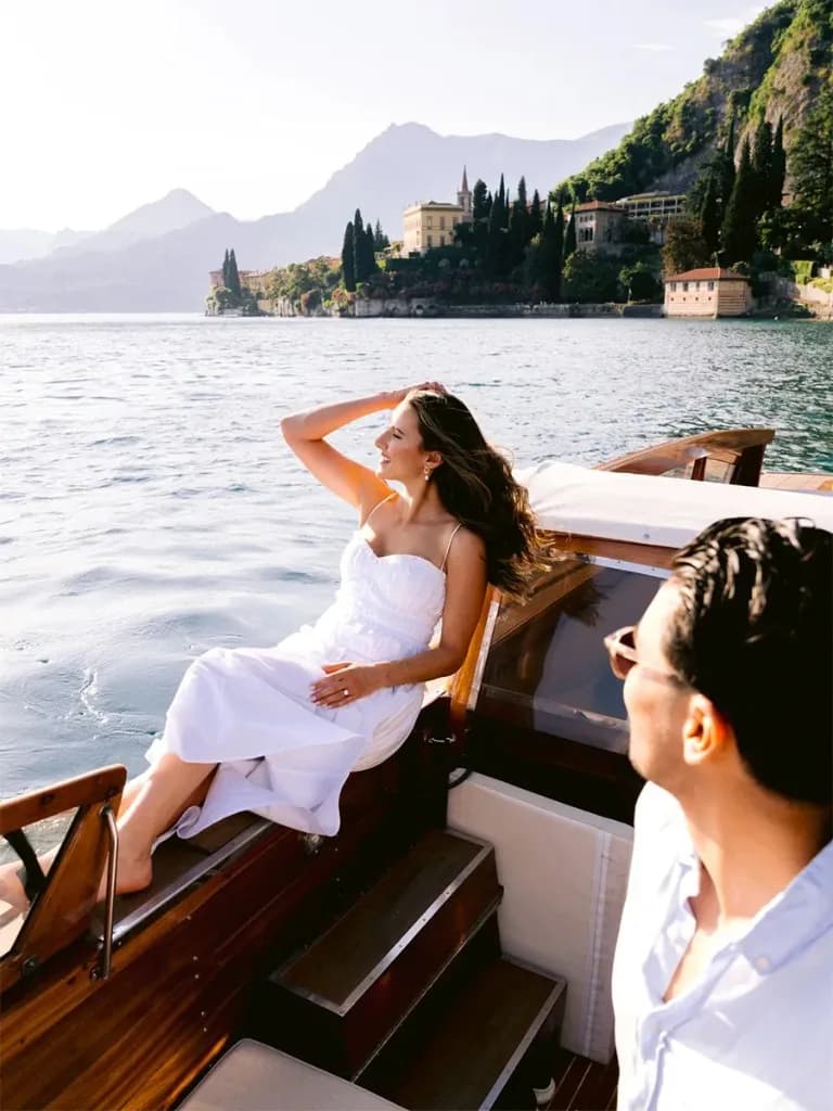Frau in Weiß auf einem klassischen Holzboot vor dem Comer See